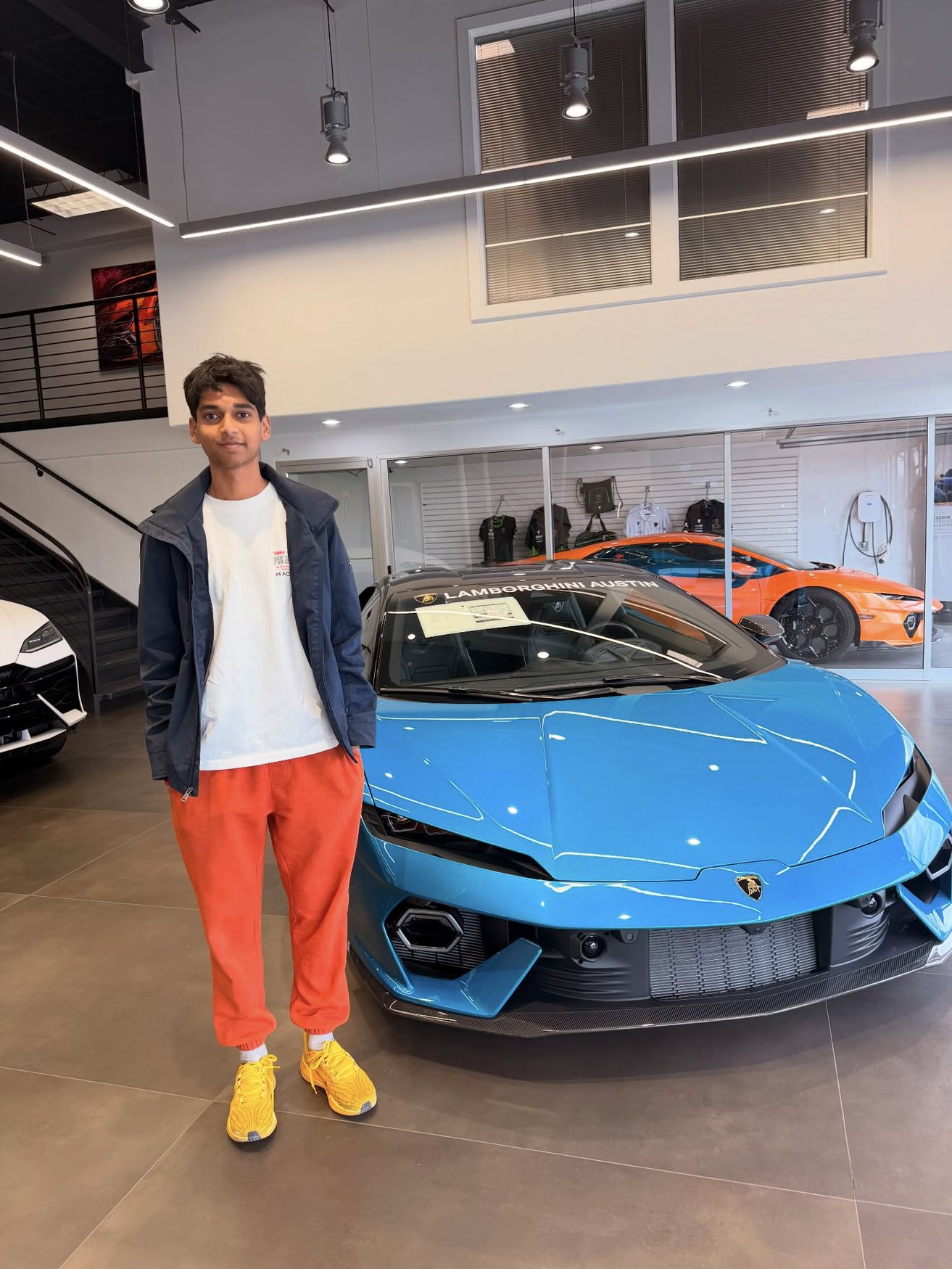 Rehan Raj posing with a Lamborghini at Lamborghini Austin for Miguel's Best Day Ever