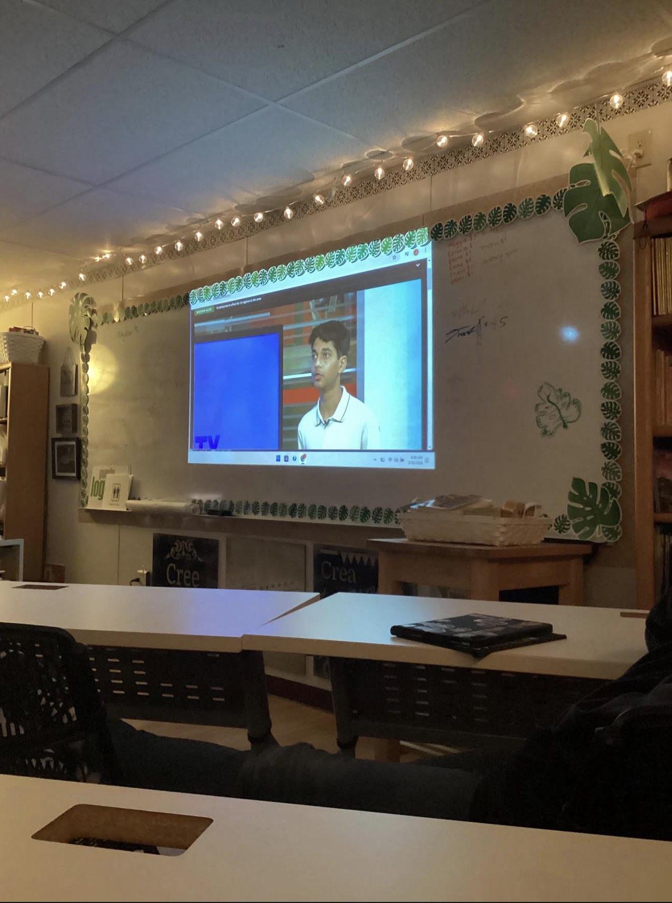 A classroom screen showing Rehan Raj's live KSAT interview on Good Morning San Antonio