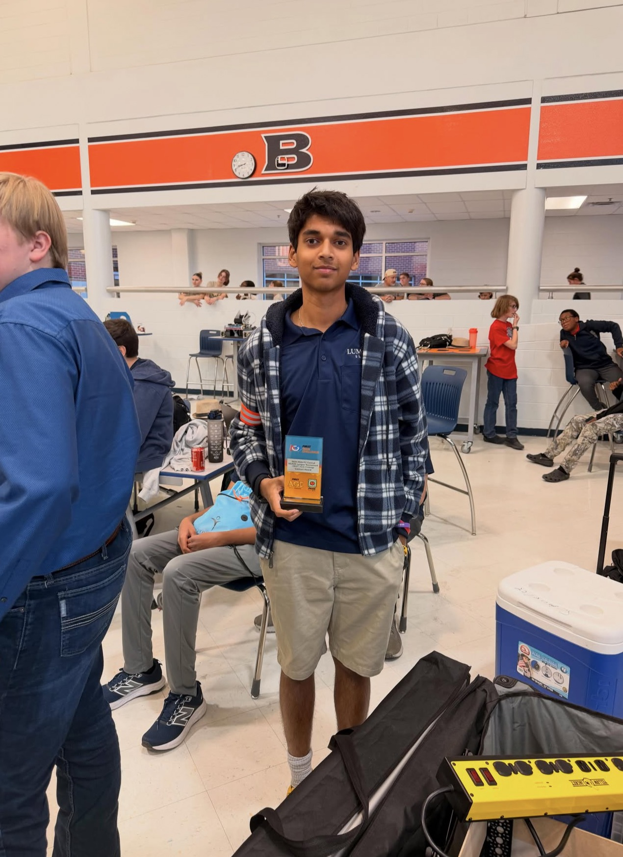 Rehan Raj holding the robotics team's first place Connect Award, a team award that advanced the team to regionals